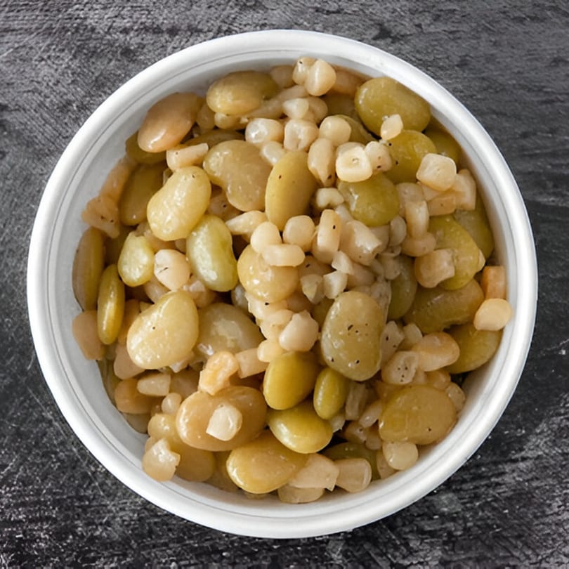 A white bowl filled with a southern side dish of lima beans and corn.